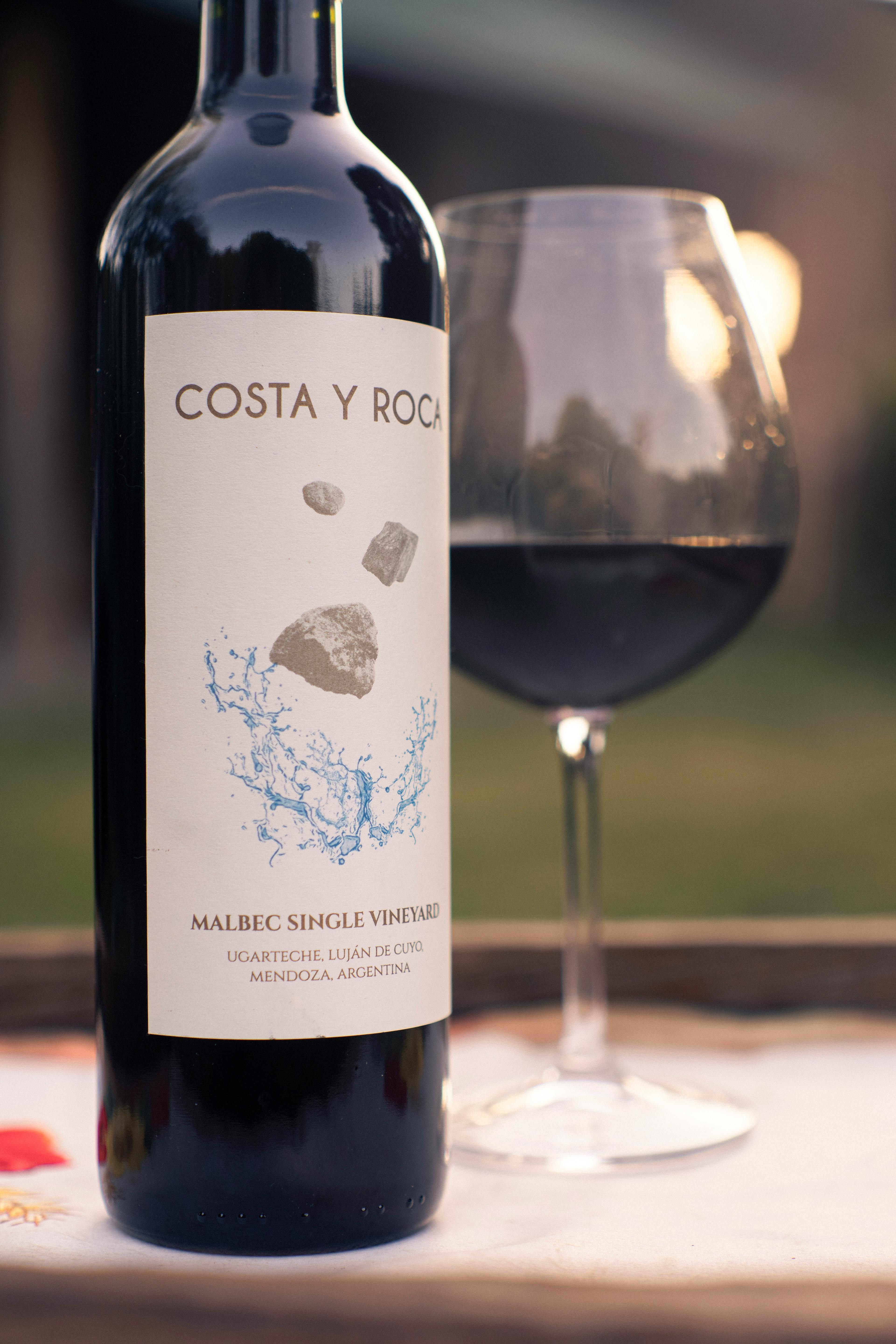 Botella real de vino Malbec con copa, usada como asset demo del banco visual.
